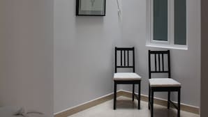 Una habitación con tragaluz, una obra de arte enmarcada, dos sillas y una ventana.