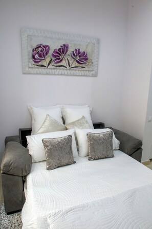 A bedroom with a bed, pillows, and a wall-mounted artwork. - Panther Home Luxury Dreams (Casco Historico)