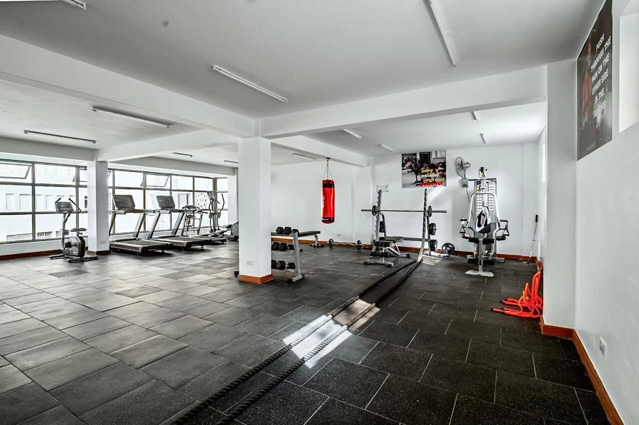 A gym with treadmills, weight machines, and a punching bag.