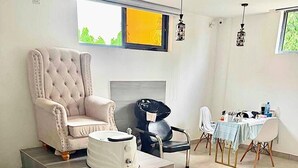 Una sala de estar con un sofá, una mesa de comedor con sillas, una mesa de centro y un televisor.