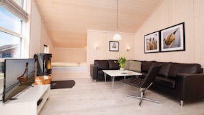 Ein modernes Wohnzimmer mit einer Couch, einem Couchtisch und einem Fernseher.