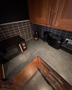 A kitchen with a microwave, toaster, and coffee maker on the countertop. - Elegant 2-Bed w/ Balcony | City Centre (Liverpool)