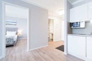 Um apartamento moderno com um quarto, cozinha e banheiro.