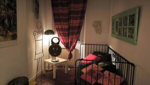 Ett barnrum med en säng, ett skrivbord, en lampa och en vägg med bilder.