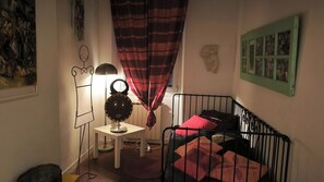 Kinderzimmer mit Bett, Schreibtisch, Lampe und Wand mit Bildern.