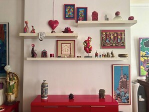 Ein Zimmer mit einem roten Schrank, Regalen voller Dekoration und einem gerahmten Bild der Freiheitsstatue.