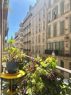 Ein Balkon mit einem Blumentopf und einem kleinen Tisch.
