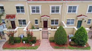A row of townhouses with a gated entrance, numbered 2320 and 2326, and a sign indicating permit parking only. - 3BR Resort Townhome Near Disney Free Amenities (Davenport)