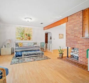 A spacious room with a bed, a fireplace, and a large window. - 3BR Pool Home for 8 Easy Access to I-75 and I-4 (Valrico)