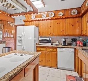 A kitchen with wooden cabinets, a white refrigerator, a microwave, a coffee maker, and a dishwasher. - 3BR Pool Home for 8 Easy Access to I-75 and I-4 (Valrico)