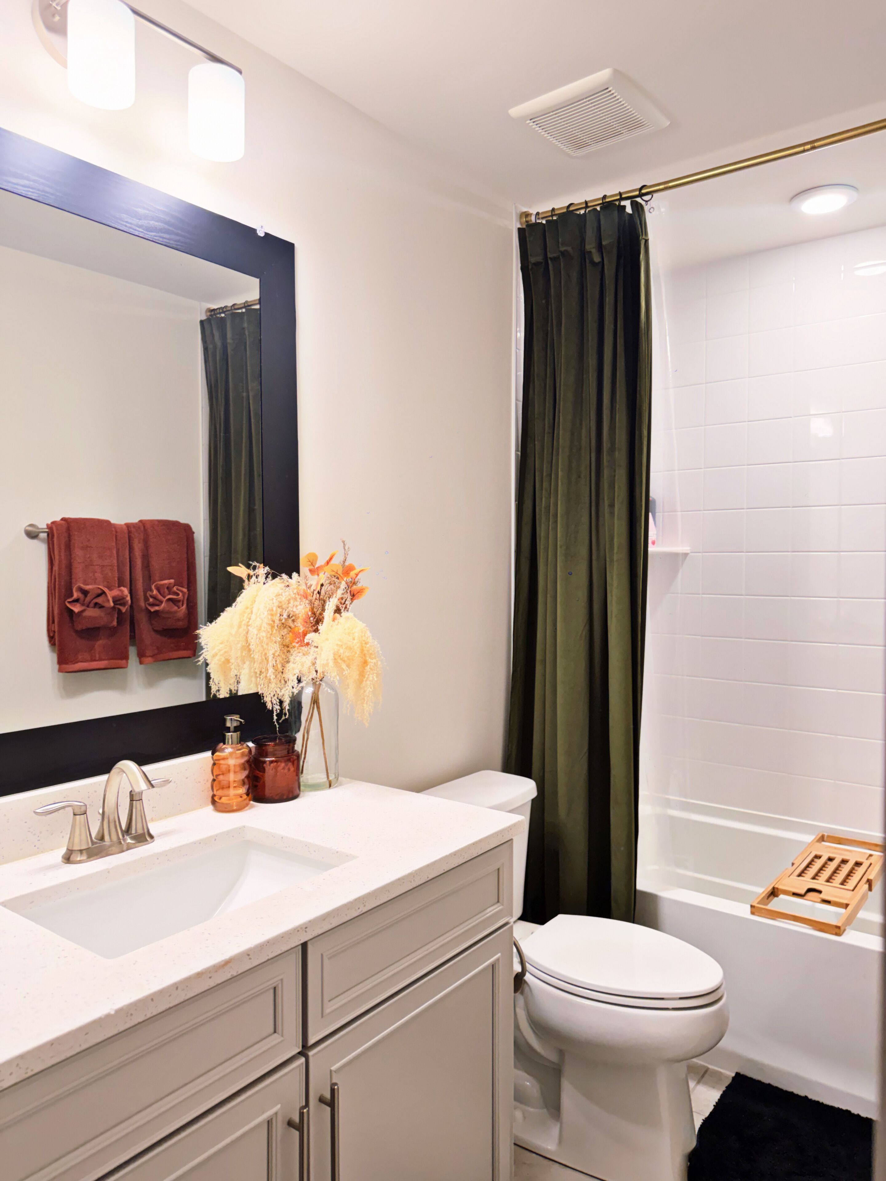 A bathroom with a white sink, a mirror, a toilet, and a shower curtain.