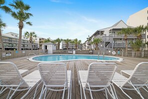 Ein Poolbereich mit Liegestühlen und einer Holzterrasse.