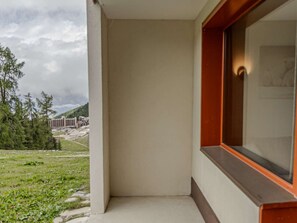 A balcony with a view of a building complex and a grassy area. - Renovated apartment at the foot of the slopes - 4 guests (Belle Plagne)