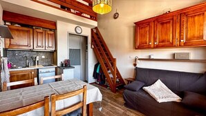 A cozy interior with a dining area, kitchen, and a staircase leading to an upper level. - Comfortable duplex studio - 4 guests (Crest-Voland)