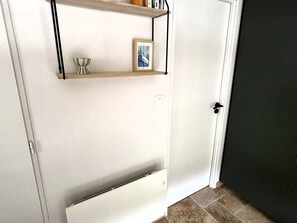 A white door with a shelf above it and a lower shelf below. - Central apartment with parking - 4 guests (Les Gets)