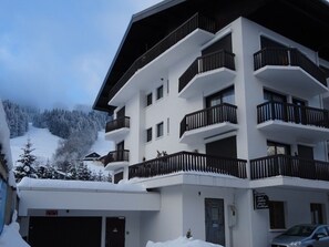 Ein mehrstöckiges Hotel mit Balkonen, einer Garage und einem Schild, das ein Restaurant anzeigt.