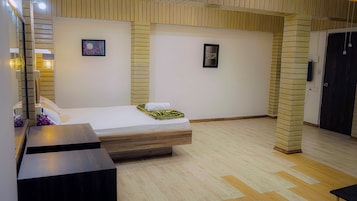 Quarto de hotel com cama, mesa de cabeceira, espelho e um quadro na parede.