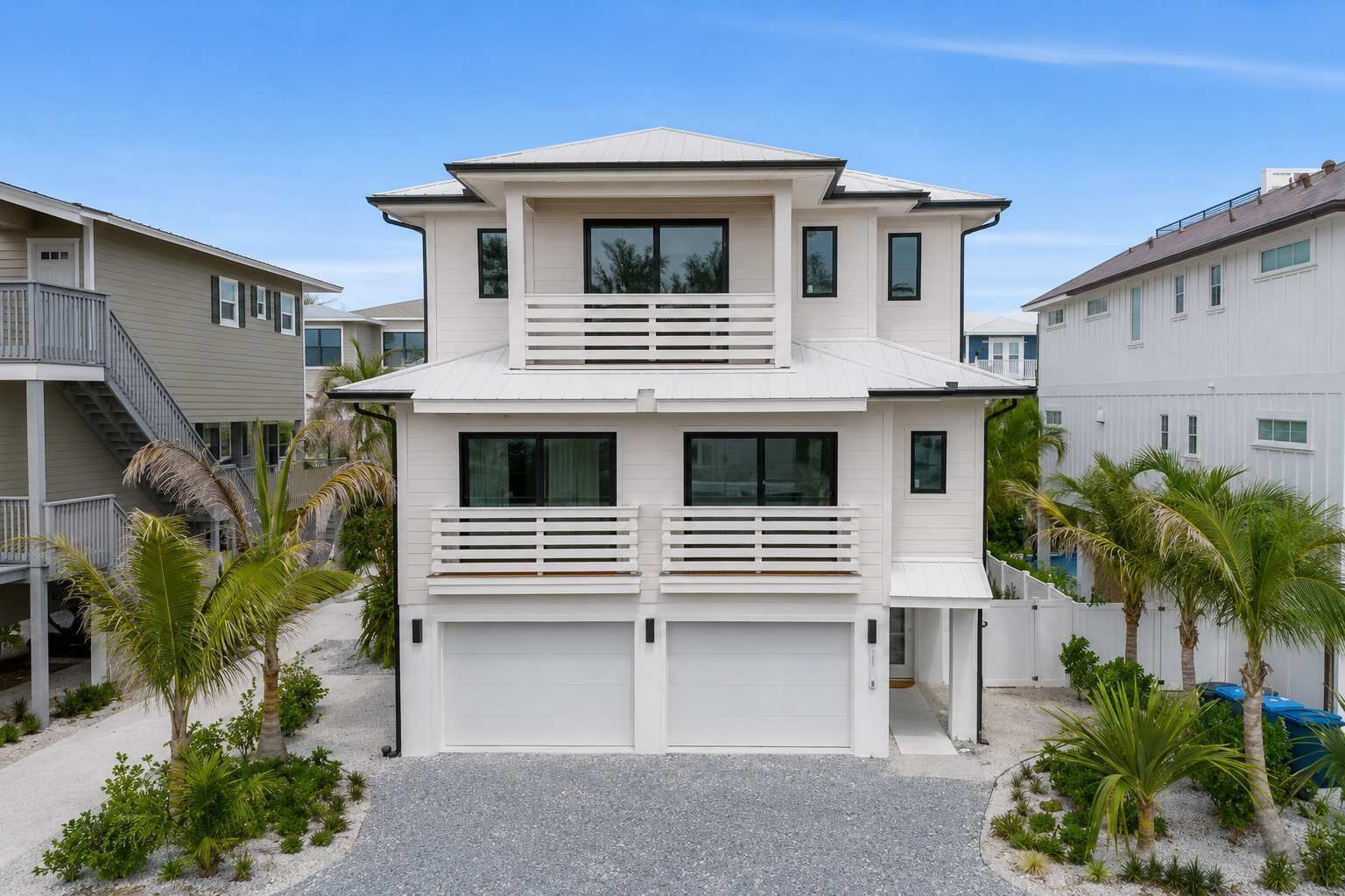 A two-story residential building with a flat roof, large windows, and a covered garage.