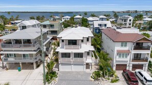 A coastal residential area with multi-story houses, a marina, and a clear view of the ocean. - Brand New, Heated Pool/Spa, Minutes to Beach (Bradenton Beach)