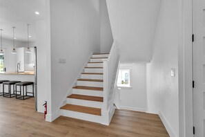 Eine moderne Küche mit Holzarbeitsplatten, einem eingebauten Ofen und einer Bar mit Hockern.