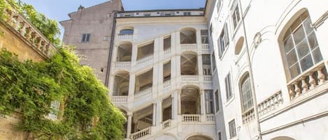 Uma rua estreita com edifícios com varandas e janelas em arco.