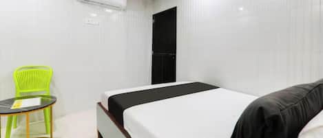 Una habitación de hotel con una cama, una silla y una mesita.
