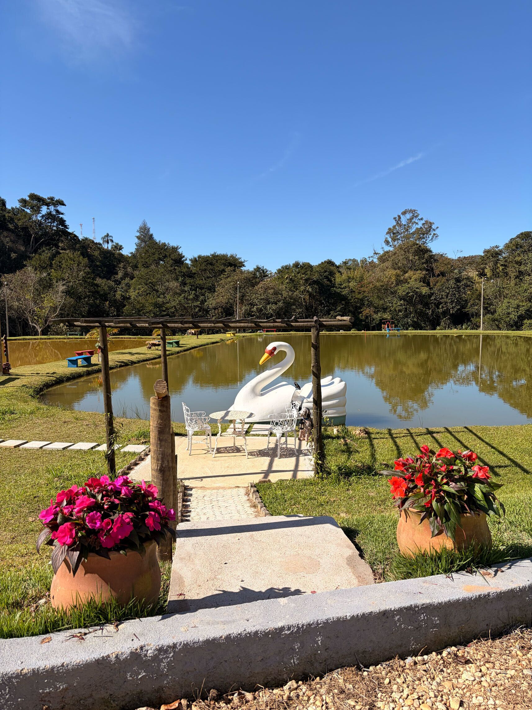 Un parco tranquillo con uno stagno, una scultura di cigno e zone relax.