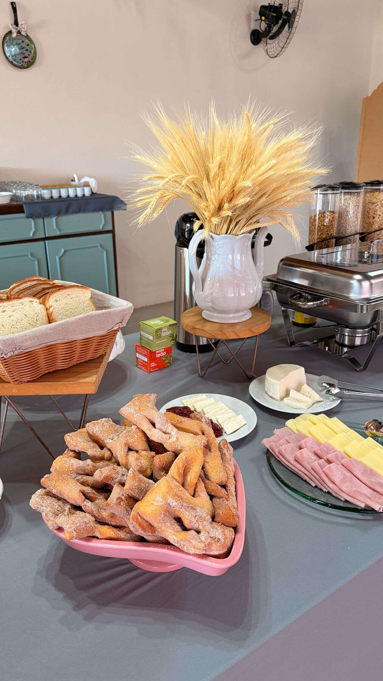 Una mesa de buffet con pan, pasteles, queso y jamón.
