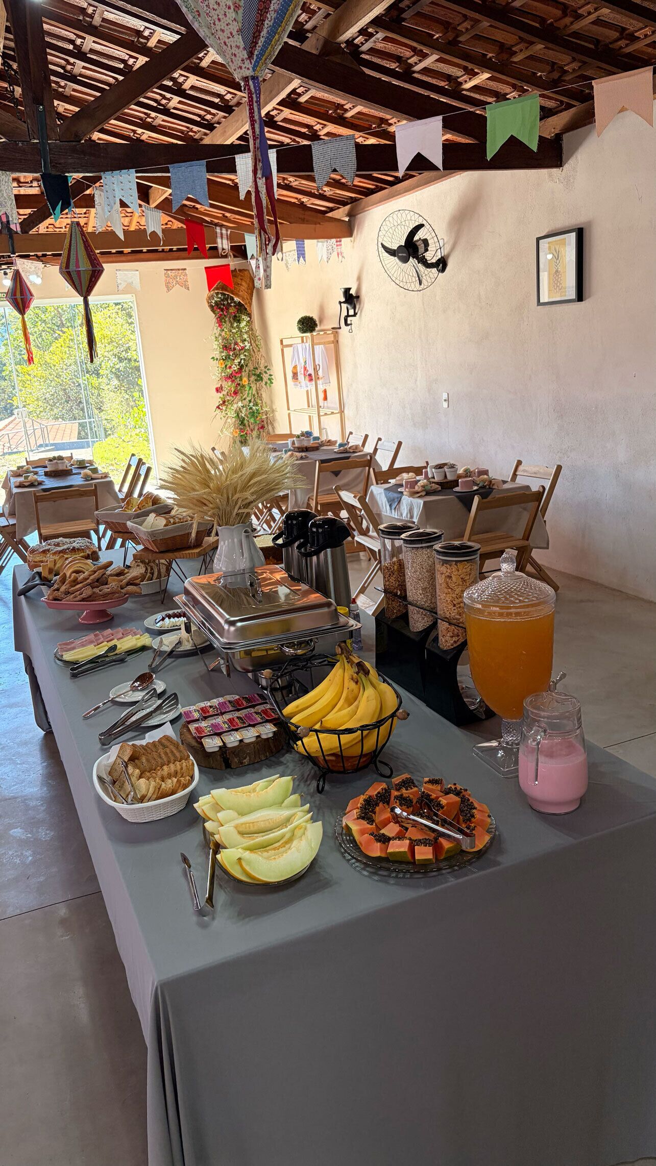 A buffet table with various food items and a pitcher of orange juice.
