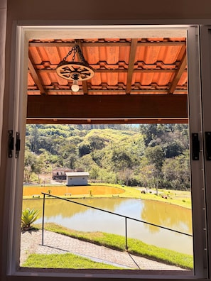 A view through a door of a building with a wooden ceiling and a hanging light fixture.