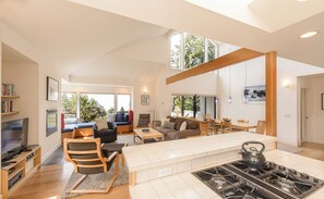 A modern living space with a kitchen, dining area, and seating area. - Sea Ridge (TOT ID #2175): 3  BR, 3  BA House in The Sea Ranch, Sleeps 6 (The Sea Ranch)
