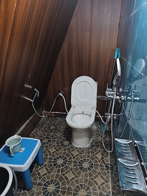 A bathroom with a toilet, a bidet, and a shower.