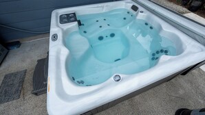 Boblebad med kontrolpanel, afløb og en fodpedal.