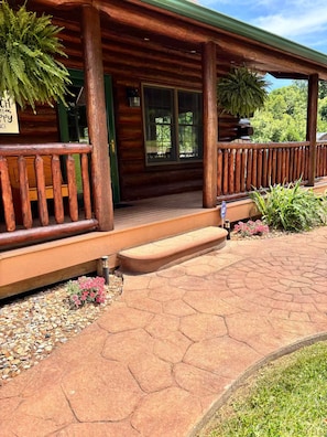 A wooden cabin with a porch, steps leading to the entrance, and a sign that reads 'My Happy Place'.
