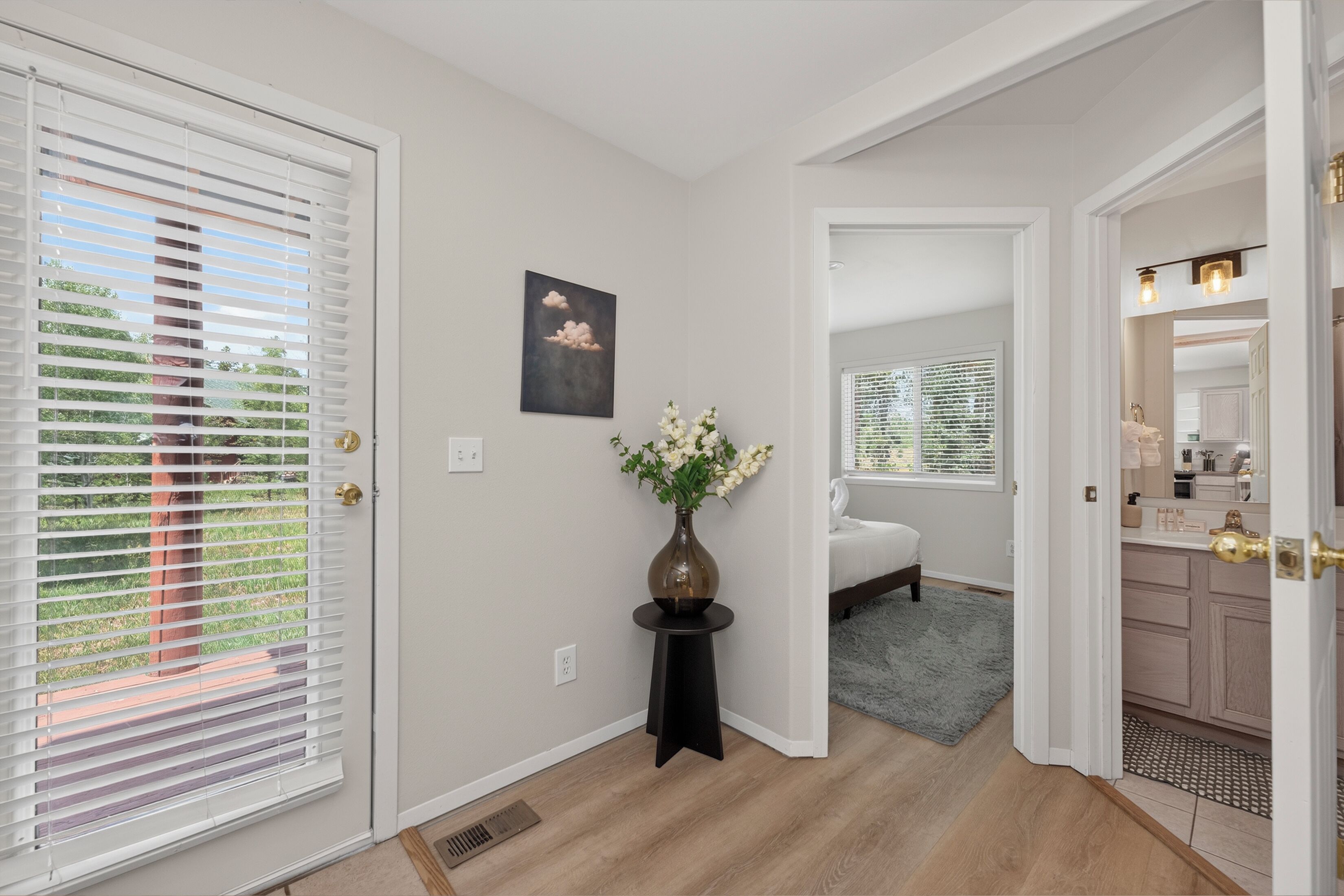 A hallway with a door leading to a bedroom, a bathroom, and a living area.