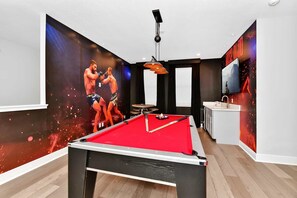 Une pièce équipée d’une table de billard, d’une table de snooker et d’un téléviseur.