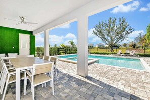 Eine Außenpatio mit Pool, Sitzbereich und Blick auf die umliegende Nachbarschaft.