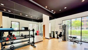 A modern gym with exercise equipment, large windows, and a wooden floor. - Golden Hour 1BR | Creek Beach with Lagoon Access (Dubai)