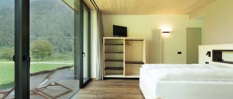Quarto com cama, televisão e guarda-roupa.