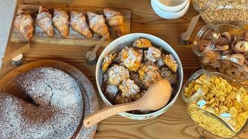 Diversa variedad de postres y pasteles sobre una mesa de madera, incluyendo tartas, bizcochos y galletas.
