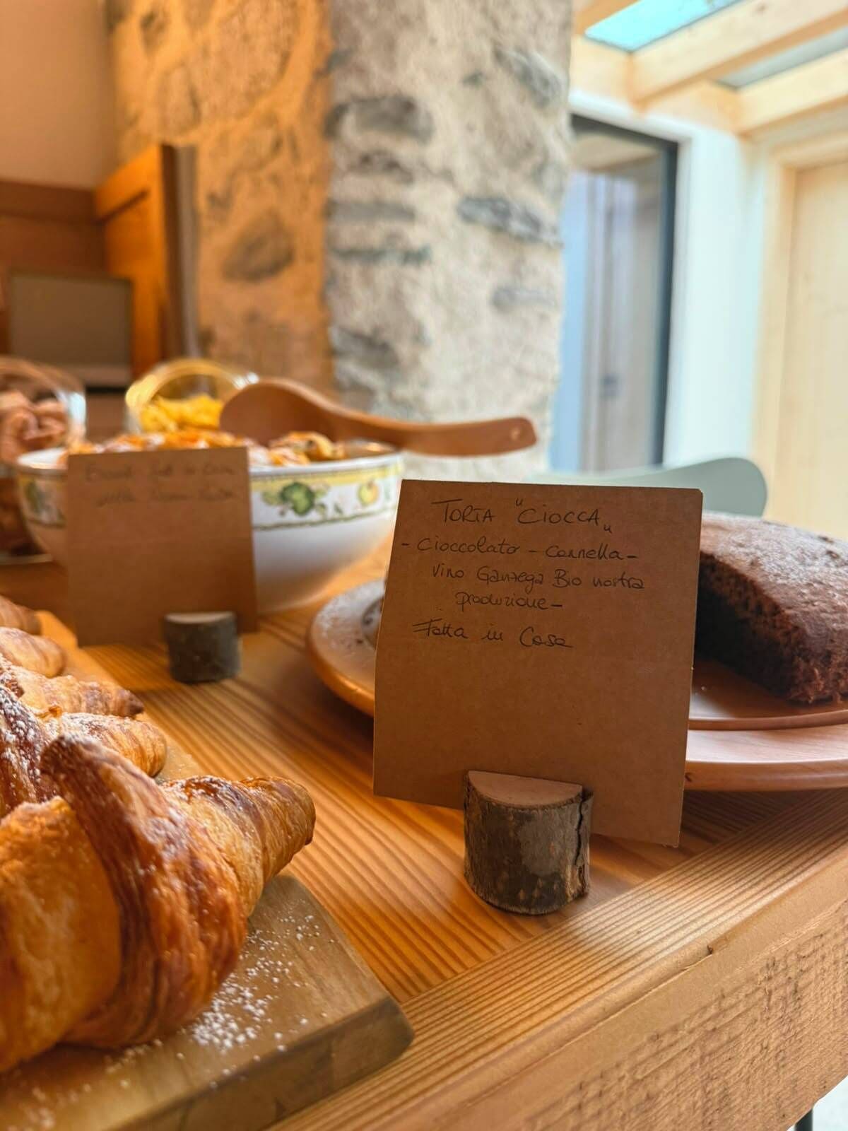 Un bufé de desayuno con diversas opciones de pastelería y un cartel que indica el menú.