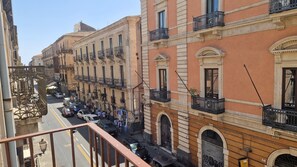 A street view with multi-story buildings, balconies, and parked cars. - House Centro Storico Bonfatto, Downtown Catania.  Phone: +39 3205572388. (Catania)