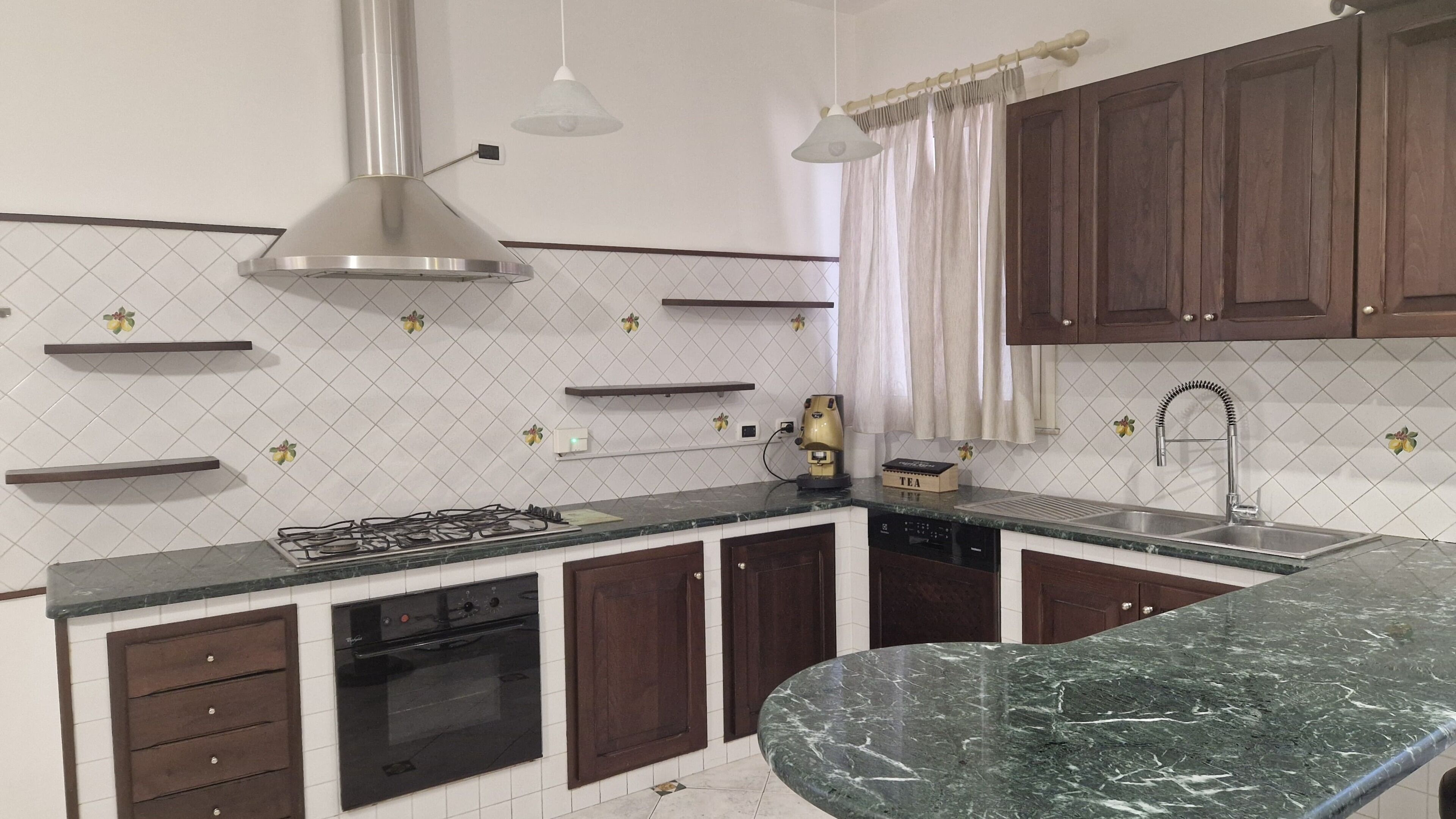 A kitchen with a gas stove, oven, and a marble countertop.