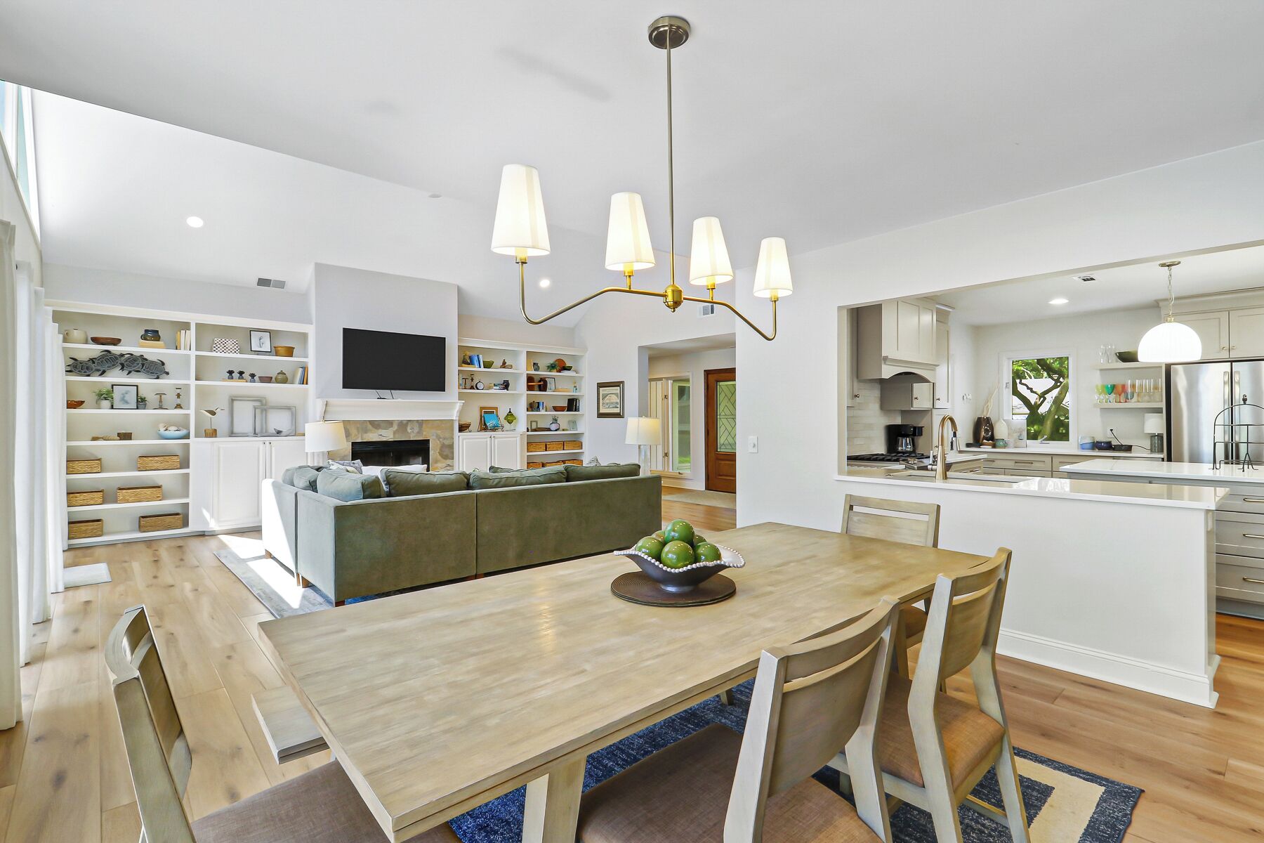 Una cocina moderna con zona de comedor, estanterías integradas y televisor.
