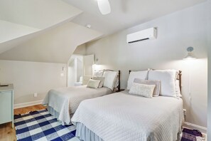 A bedroom with two beds, a ceiling fan, an air conditioning unit, and a checkered rug. - Sunset Rentals | Port Tack 67 (Hilton Head Island)