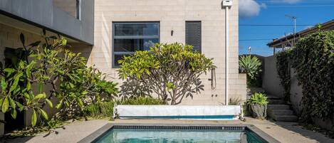 A swimming pool with a tiled edge, surrounded by a concrete deck.