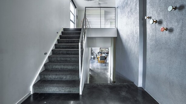 A staircase leading to a second-floor area with a dining table and chairs visible in the background. - Pool, Across from the Beach, Pet Friendly Home (Ocean Grove)