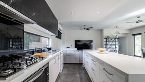 A modern kitchen with a central island, built-in appliances, and a large window. - Pool, Across from the Beach, Pet Friendly Home (Ocean Grove)