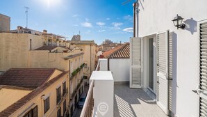 A narrow urban street with buildings on both sides, a clear sky, and a sun shining. - Estay - Lovely Marina Roof (Cagliari)