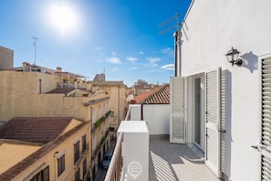 A narrow urban street with buildings on both sides, a clear sky, and a sun shining. - Estay - Lovely Marina Roof (Cagliari)